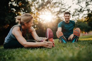 Fitness,couple,stretching,outdoors,in,park.,young,man,and,woman