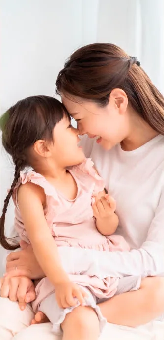 Smiling mother and young daughter touching foreheads