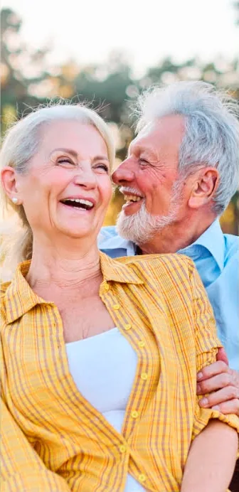Laughing senior couple embracing outdoors