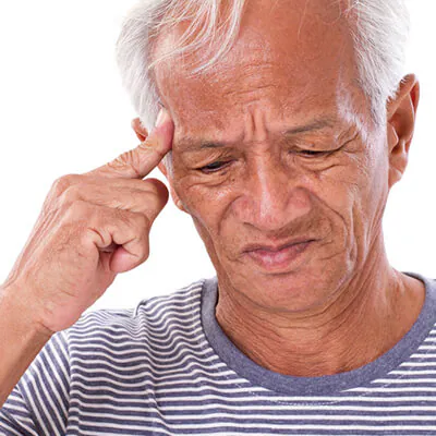 Senior man in a striped shirt touching his temple and frowning in discomfort, showing signs of headache or confusion