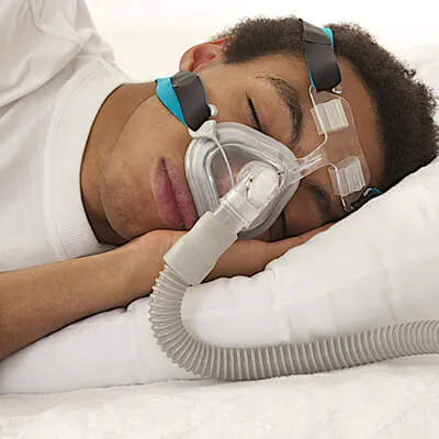 Man sleeping with a CPAP mask on his face, used for sleep apnea treatment.