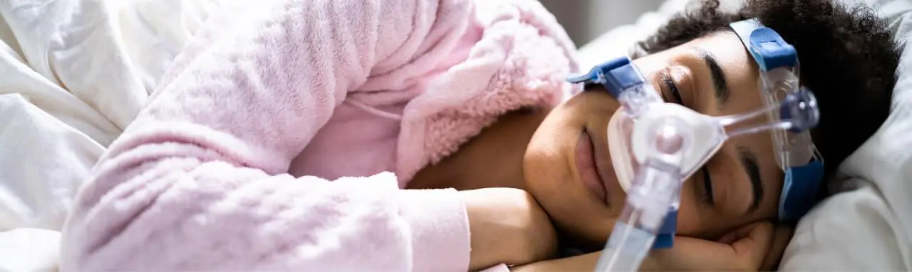 Person sleeping peacefully with CPAP mask for sleep apnea treatment.